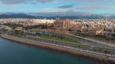 Palma de Mallorca şehir manzarası. La Almudaina 'daki Santa Maria Kraliyet Sarayı' ndan La Seu Katedrali, güneşli bir günde eski bir mimari drone. Seyahat, dönüm noktası, ünlü bir yer. Balear Adaları. İspanya