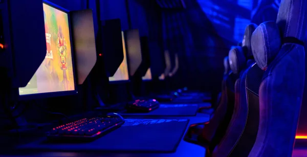 インターネットカフェの中には 青いネオンライト 照明付きのサイバーカフェルーム コンピュータの空の椅子が並ぶテーブル 誰もいません ゲーマーのための近代的な場所 コンピュータゲームの競争 楽しい Eスポーツの概念 — ストック写真