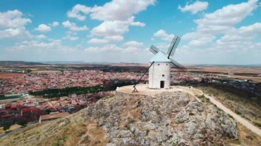 Castilla-La Mancha 'nın sembolü olan Consuegra kasabasındaki ünlü yel değirmenleri bulutlu gökyüzü arka planına karşı insansız hava aracı bakış açısı. Toledo konseptinde tarih ve miras. Avrupa, Toledo. İspanya