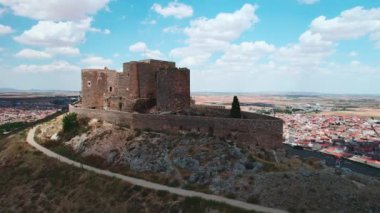 Güneşli bir günde Consuegra tarihi kasabasındaki La Muela 'nın insansız hava aracı manzaralı kalesi. Toledo ili, Kastilya-La Mancha, İspanya. Miras, dönüm noktaları konsepti