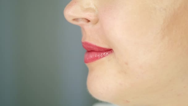閉じますクロップドビュー原因アジアの若い女性の顔 顔料アプリケーションマイクロ色素沈着化粧品手順の後の唇 リップグロス効果を持つアクエラレブラッシング技術 美容治療のコンセプト — ストック動画