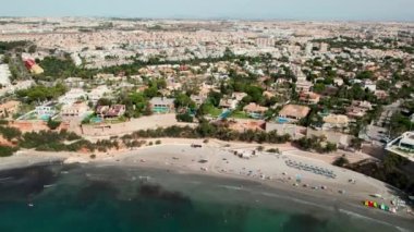 Akdeniz sörfü, Cabo Roig 'in kumlu plajı, şehir manzarası, hava aracı bakış açısı. İspanyol turizm beldesi, tropikal doğa, yerleşim bölgesi. Yaz tatili konsepti. Costa Blanca 'da. İspanya