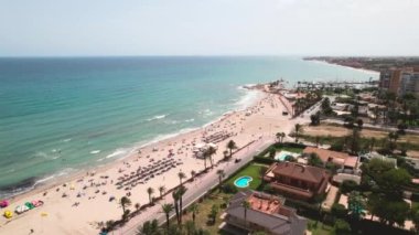 İspanyol turizm beldesi Costa Blanca 'daki Dehesa de Campoamor hava aracı bakış açısı, Akdeniz' in kumlu sahil kıyısı ve mavi-yeşil suları. Yaz tatili konsepti. Avrupa, İspanya