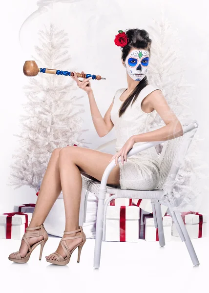 Day of the dead girl with tobacco pipe over christmas background — Stock Photo, Image