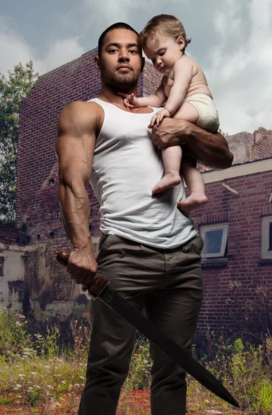 Πατέρας αγκαλιάζει ένα μωρό και την κρατάει ένα σπαθί — Φωτογραφία Αρχείου