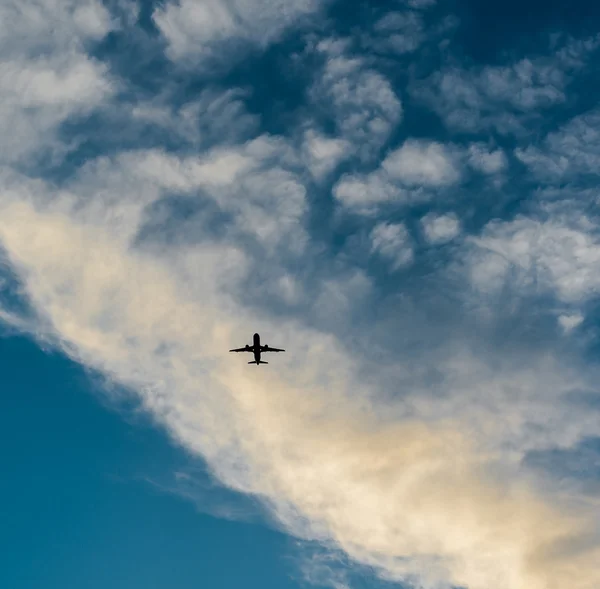 Flygplan på himlen vid solnedgången — Stockfoto