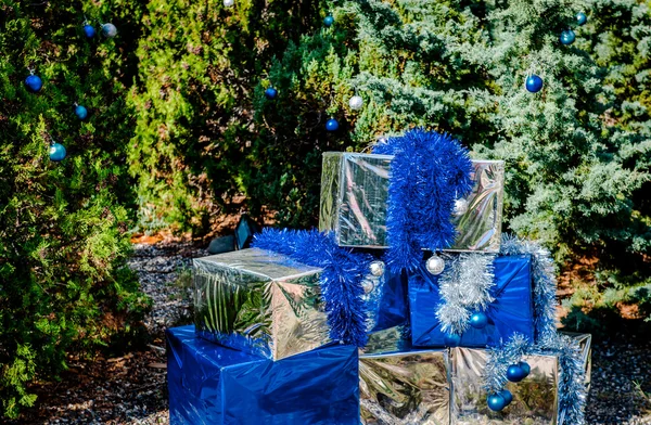 Sfondo di Natale con mucchio di scatole regalo e alberi sempreverdi — Foto Stock