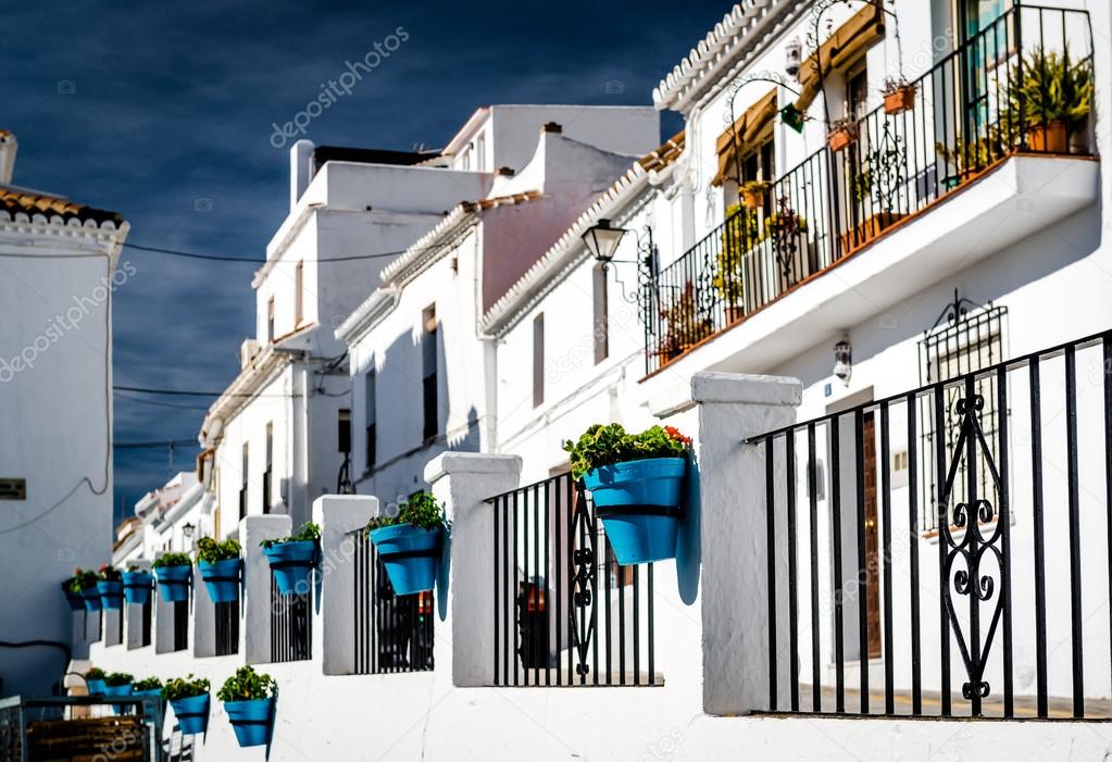 Typical spanish white village houses with flower pots. 
