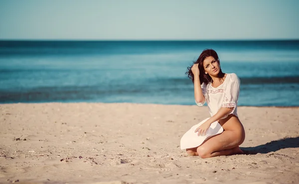 Linda jovem morena posando na praia perto do mar — Fotografia de Stock