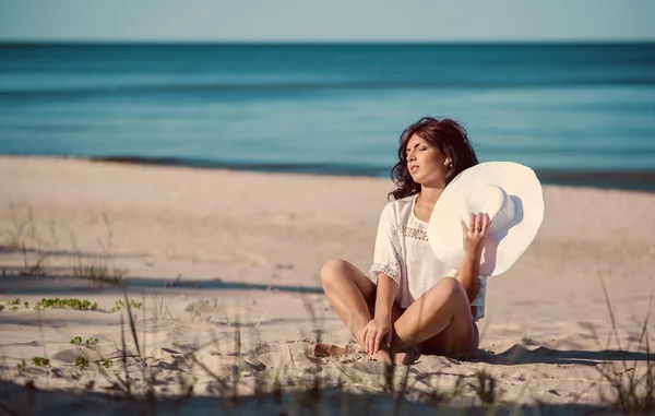 Mujer joven relajándose en la playa cerca del mar — Foto de Stock