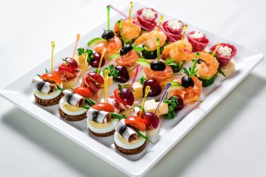 Plate with various seafood and meat canapes