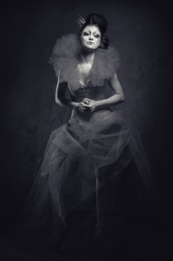 Queen. Woman with creative make-up in fluffy dress posing indoor