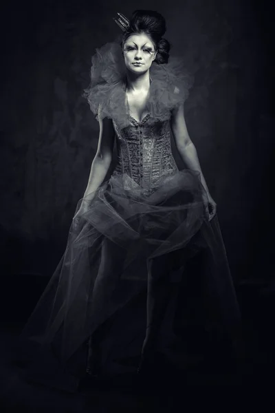 Regina. Femeie cu machiaj creativ în rochie pufoasă care pozează în interior — Fotografie, imagine de stoc
