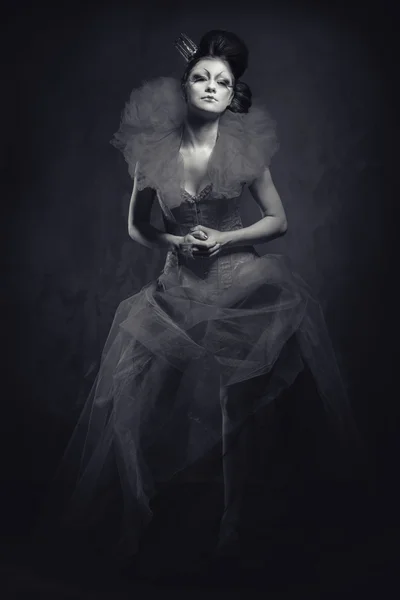 Königin. Frau mit kreativem Make-up in flauschigem Kleid posiert drinnen — Stockfoto