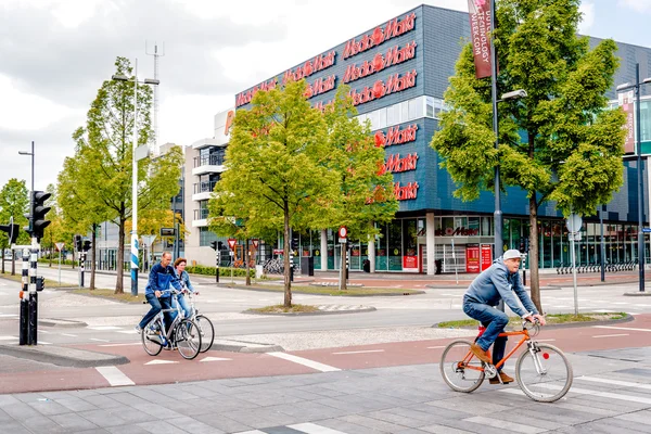 Gente cruzando la calle en bicicleta —  Fotos de Stock