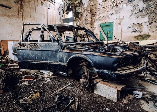 Vieille voiture détruite à l'intérieur du bâtiment ruineux — Photo