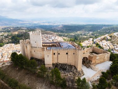 Stunning drone view of Castillo de Velez-Blanco Renaissance castle perched on rocky hill in Andalusia, Spain, surrounded by rolling hills. Medieval and Moorish heritage concept