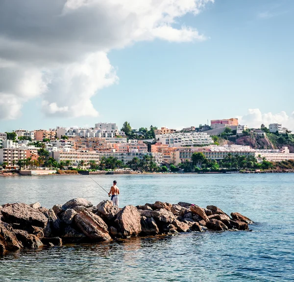 Homem com vara de pesca contra Ibiza townscape — Fotografia de Stock