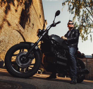 Açık havada bir kafe-racer motosiklet üzerinde oturan adam