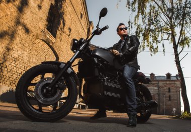 Açık havada bir kafe-racer motosiklet üzerinde oturan adam