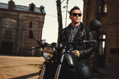 Açık havada bir kafe-racer motosiklet üzerinde oturan adam