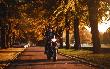 Adam açık havada bir kafe-racer motosiklet binme