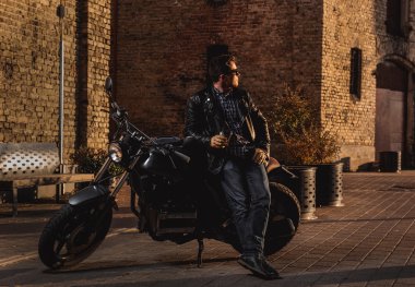 Adam açık havada bir kafe-racer Motosiklet ile