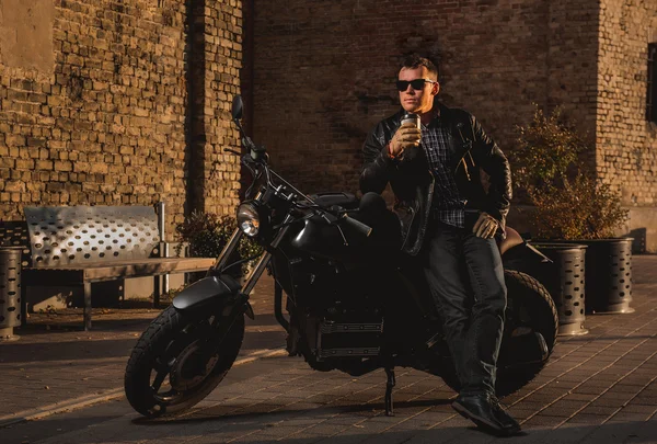 Homem com uma moto piloto de café ao ar livre — Fotografia de Stock