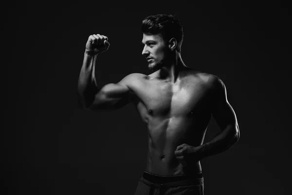 Спортсмен красивий чоловік, що показує м'язи біцепсів, студійний знімок — стокове фото
