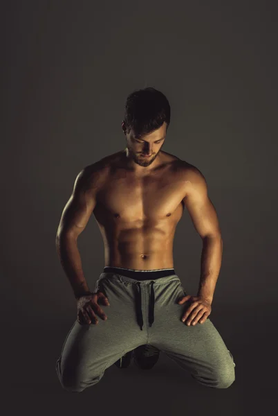 Athletisch hübscher junger Mann posiert in einem Studio — Stockfoto