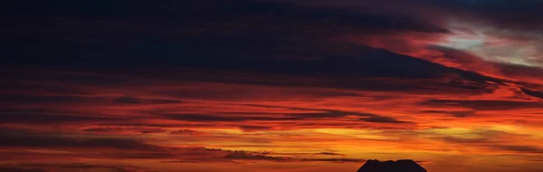 Panoramablick auf einen schönen hellen Sonnenuntergang mit bewölktem Himmel — Stockfoto