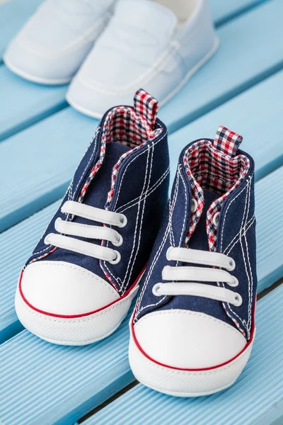 Pares de azul oscuro, zapatillas blancas del bebé y zapatos azules del bebé — Foto de Stock