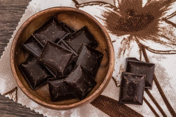 Cortar pedaços de barras de chocolate na tigela — Fotografia de Stock