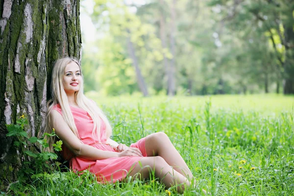 Vrouw zittend onder een boom — Stockfoto