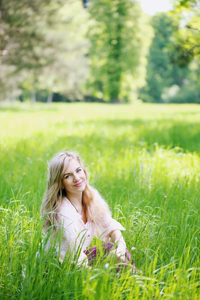 Çimenlerde oturan kız. — Stok fotoğraf