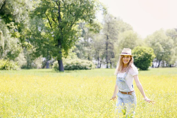 Kadın Sarı çiçekli çayır üzerinde — Stok fotoğraf