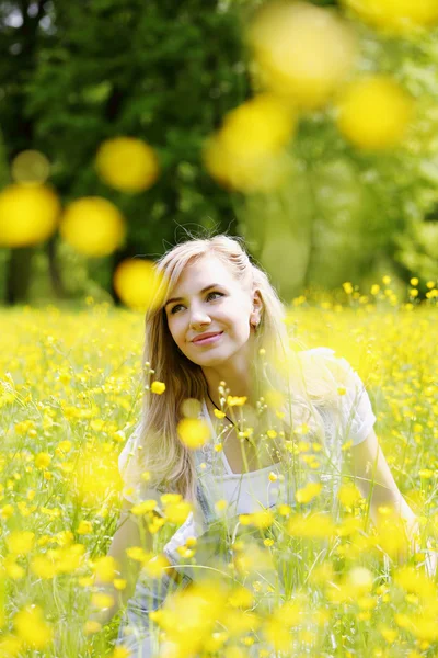 女人，花黄色的草地上 — 图库照片