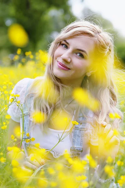 Frau auf der Wiese mit gelben Blumen, Nahaufnahme — Stockfoto