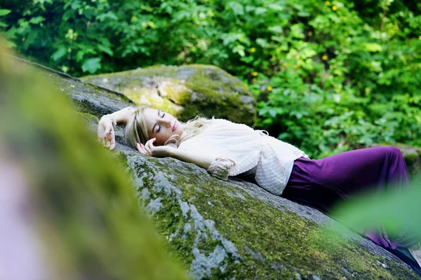 Girl sleep in a forest on the rock — Stock Photo, Image