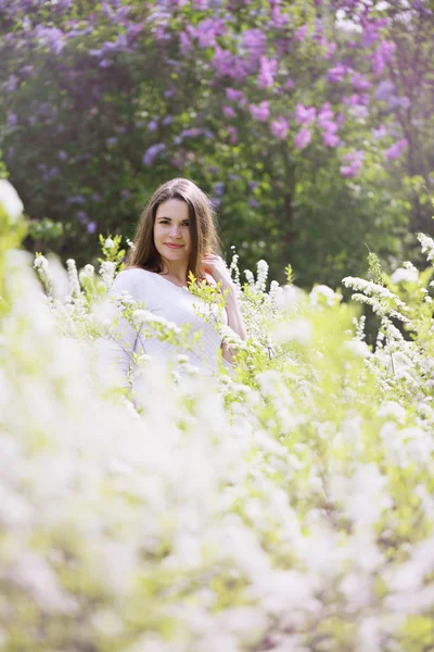 Retrato de uma menina em um arbusto branco — Fotografia de Stock