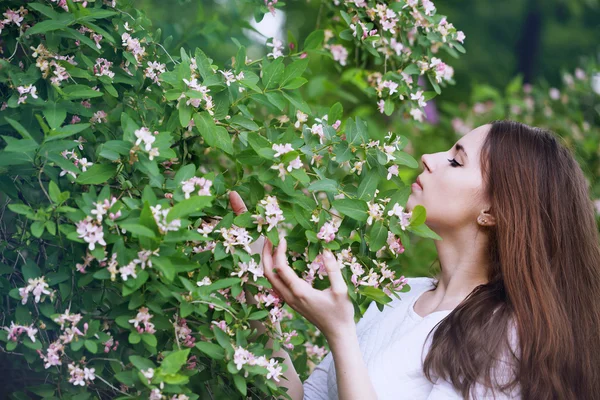 Kvinna att lukta en blomma kaprifol — Stockfoto