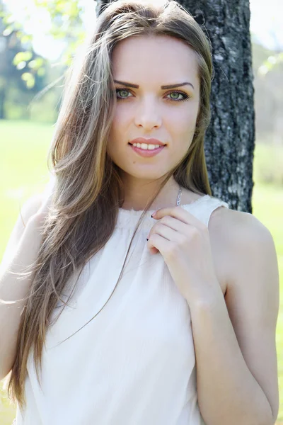 Jonge mooie vrouw in de buurt van de boom — Stockfoto