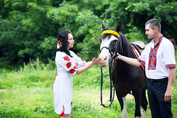 Casal em trajes ucranianos com um cavalo — Fotografia de Stock