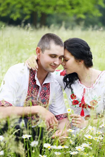 Paar auf einem Feld mit Gänseblümchen — Stockfoto