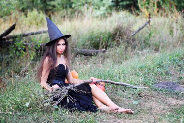 bir süpürge ile oturan cadı