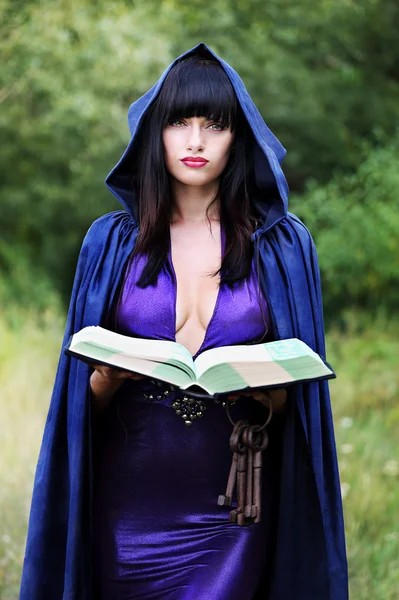 Bruja joven con un libro — Foto de Stock