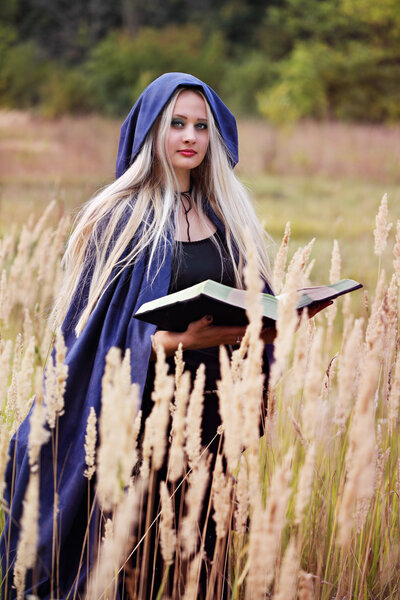 Long-haired blonde in a blue coat with a book