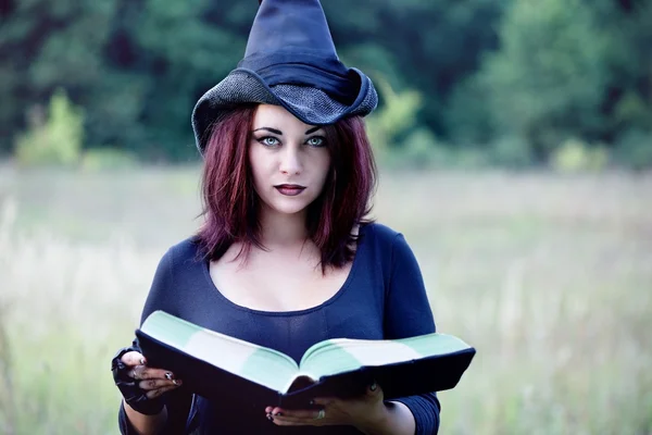 Retrato de una bruja con un libro, primer plano —  Fotos de Stock
