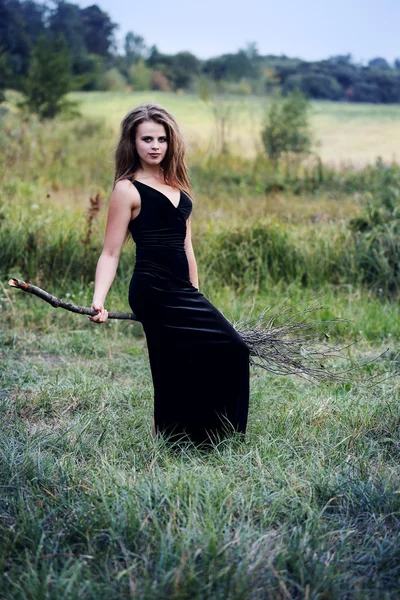 Witch sits on a broom — Stock Photo, Image