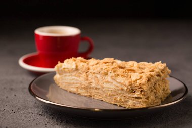 Kahve fincanında bir dilim nefis Napolyon kekiyle.